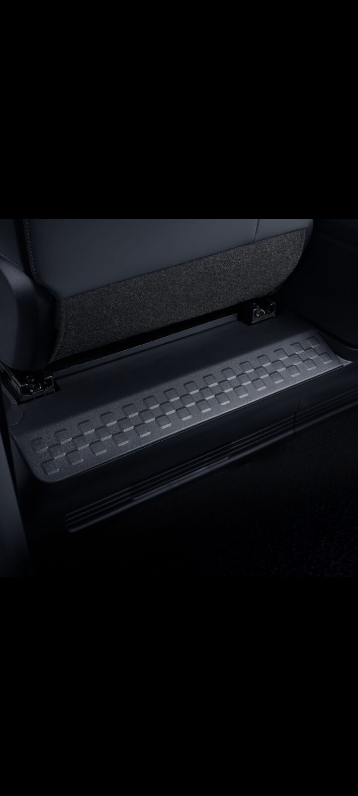 Nahaufnahme der integrierten Fußstützen unter den Rücksitzen des Kia PV5 Passenger.